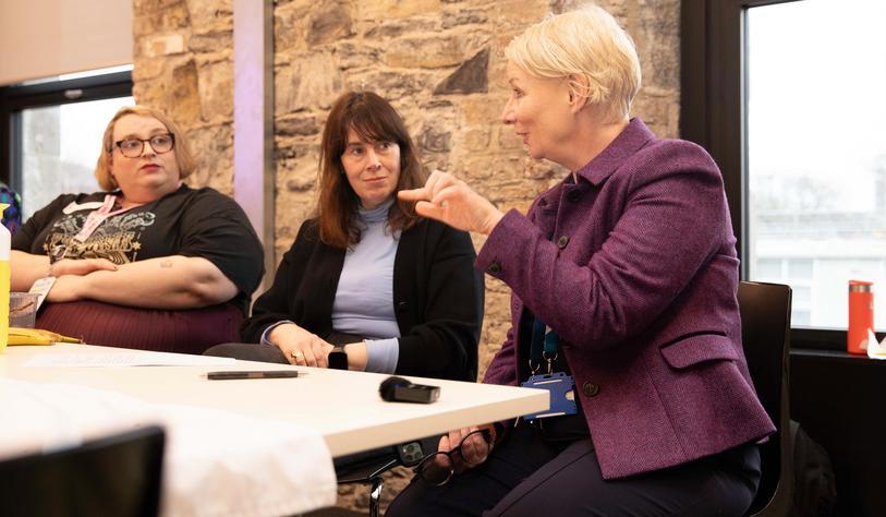 A group of people speaking at a table
