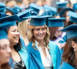 Graduates in formal conferring robes of cyan