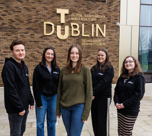 5 students standing in front of a brick building with a TU Dublin sign on the building