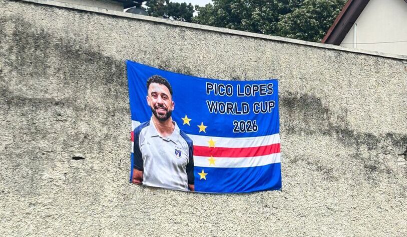 Banner on a textured gray wall featuring a smiling man in a sports shirt. Text reads